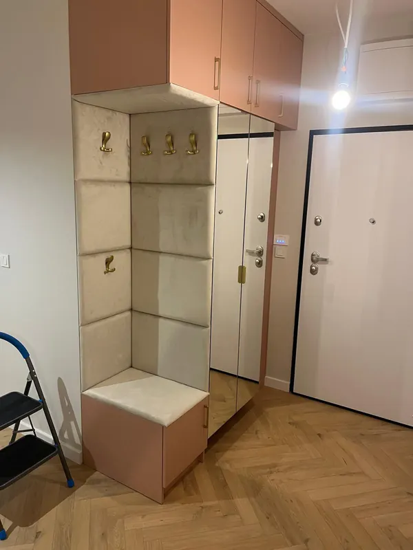 Zabudowa przedpokoju na wymiar z tapicerowanym siedziskiem, wieszakami i lustrzanymi frontami