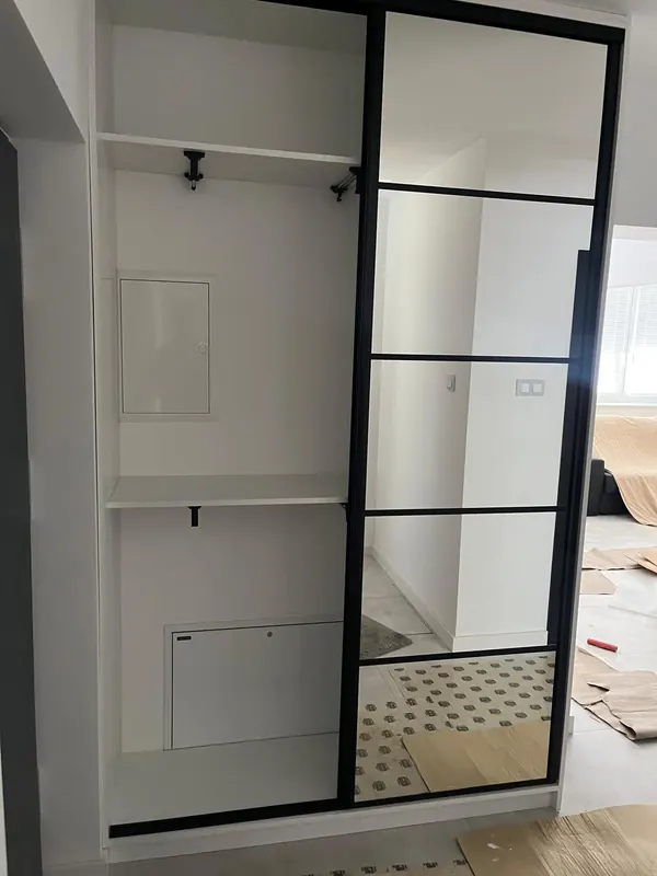 Zabudowa wnęki z lustrzanymi drzwiami przesuwnymi, półkami i drążkiem na ubrania