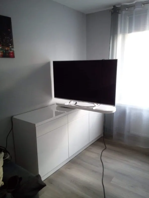 Narożna szafka RTV na wymiar z białymi frontami i wysuniętym blatem pod telewizor