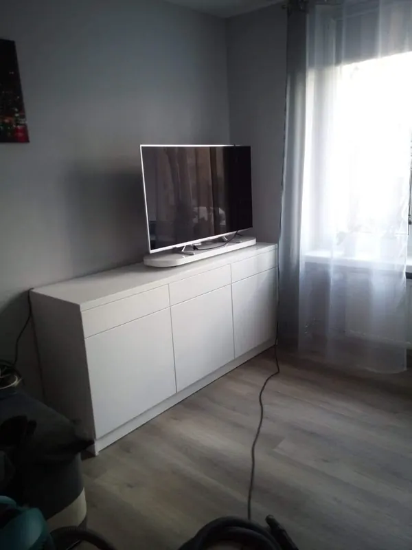 Biała komoda RTV na wymiar dopasowana do narożnika pokoju